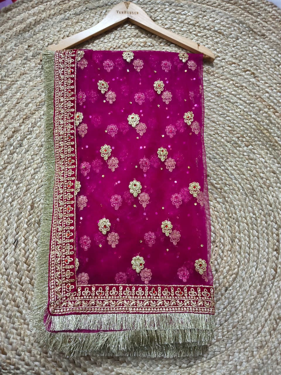 Magenta bridal dupatta on hanger against jute mat showing embroidered gold border, Veera Products